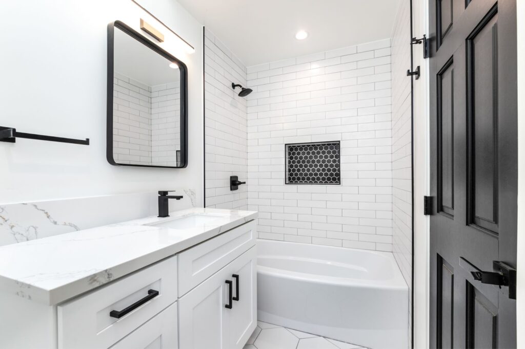 A bathroom with white tile and sleek black fixtures showcasing a modern and stylish design.