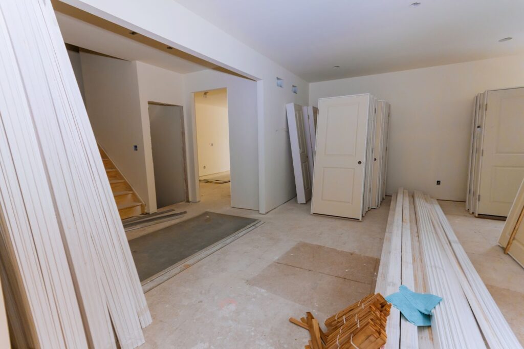 A room with a staircase and a door, part of a basement renovation project.