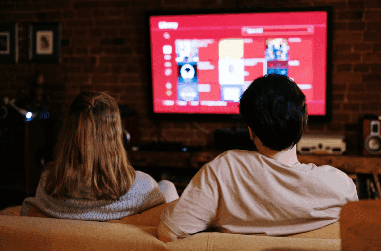 couple sit in basement with brick walls watching a large TV screen to show basement finishing Utah promoting basement renovation companies